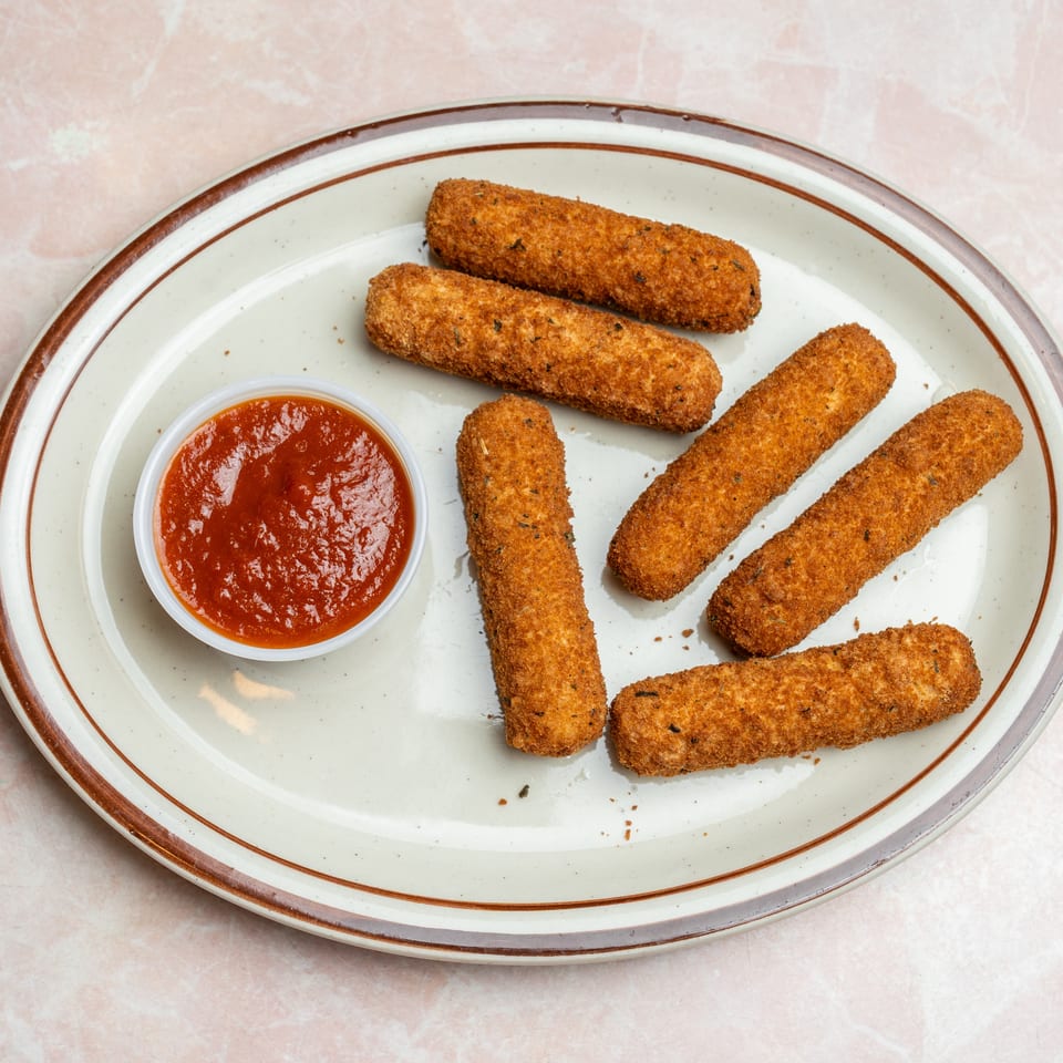 Crispy breaded mozzarella sticks arranged on a plate with a side of marinara dipping sauce.